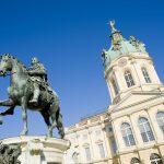 Reiterstandbild vor dem Schloss Charlottenburg, Berlin, unter einem klaren blauen Himmel.