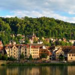 Panoramablick auf Heidelberg, Deutschland, mit dem Heidelberger Schloss, der Alten Brücke und üppigem Grün.