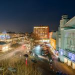 Stadtbild von Hannover bei Nacht mit der beleuchteten Gilde Parkbühne und den umliegenden Straßen.