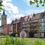 Charmante mittelalterliche Fachwerkhäuser erstrecken sich über eine Brücke am Flussufer in der malerischen, grünen Stadt Erfurt.