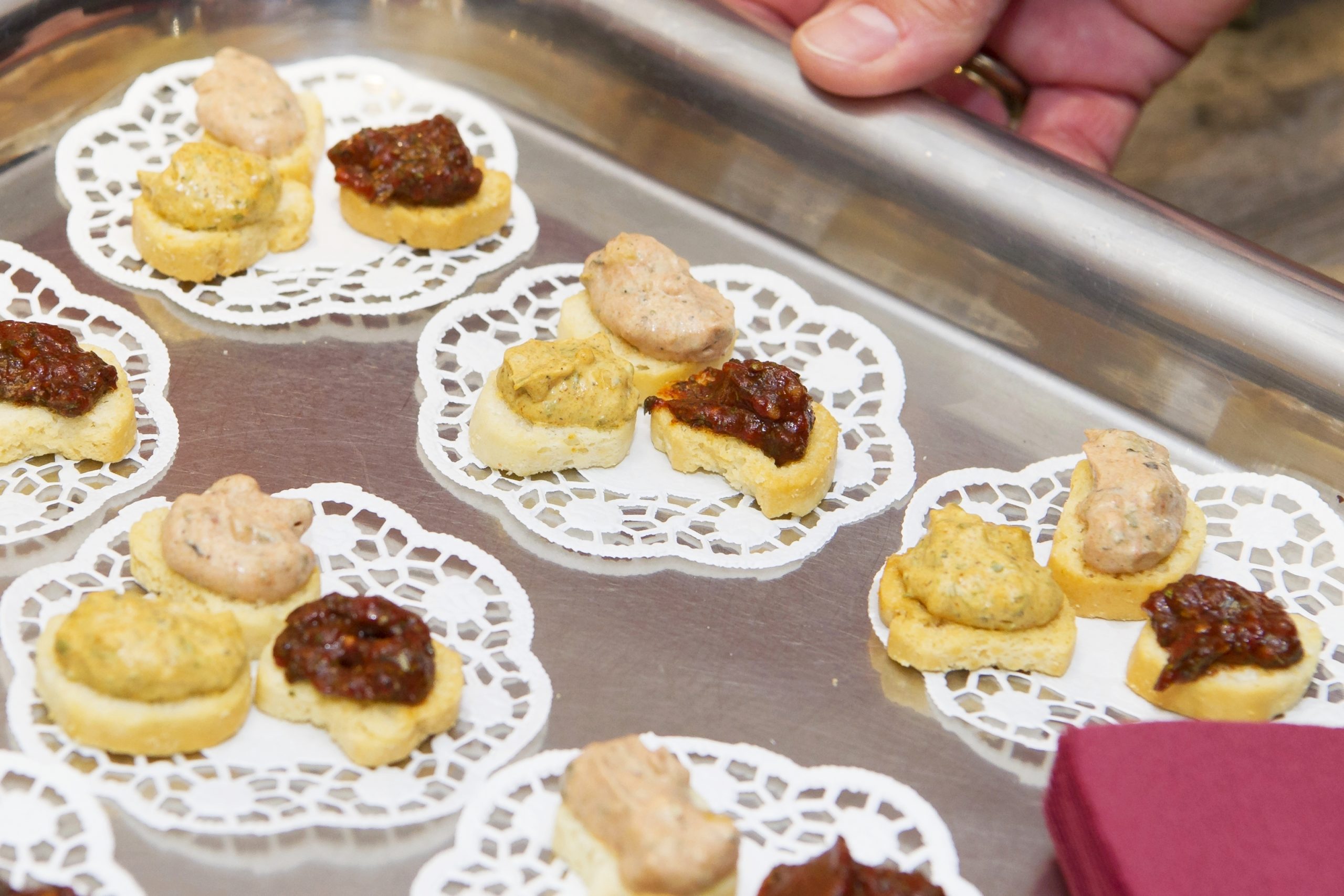 Ein Tablett mit verschiedenen Canapés auf Spitzendeckchen und unterschiedlichen Belägen verleiht einer formellen Weihnachtsfeier den perfekten Rahmen.