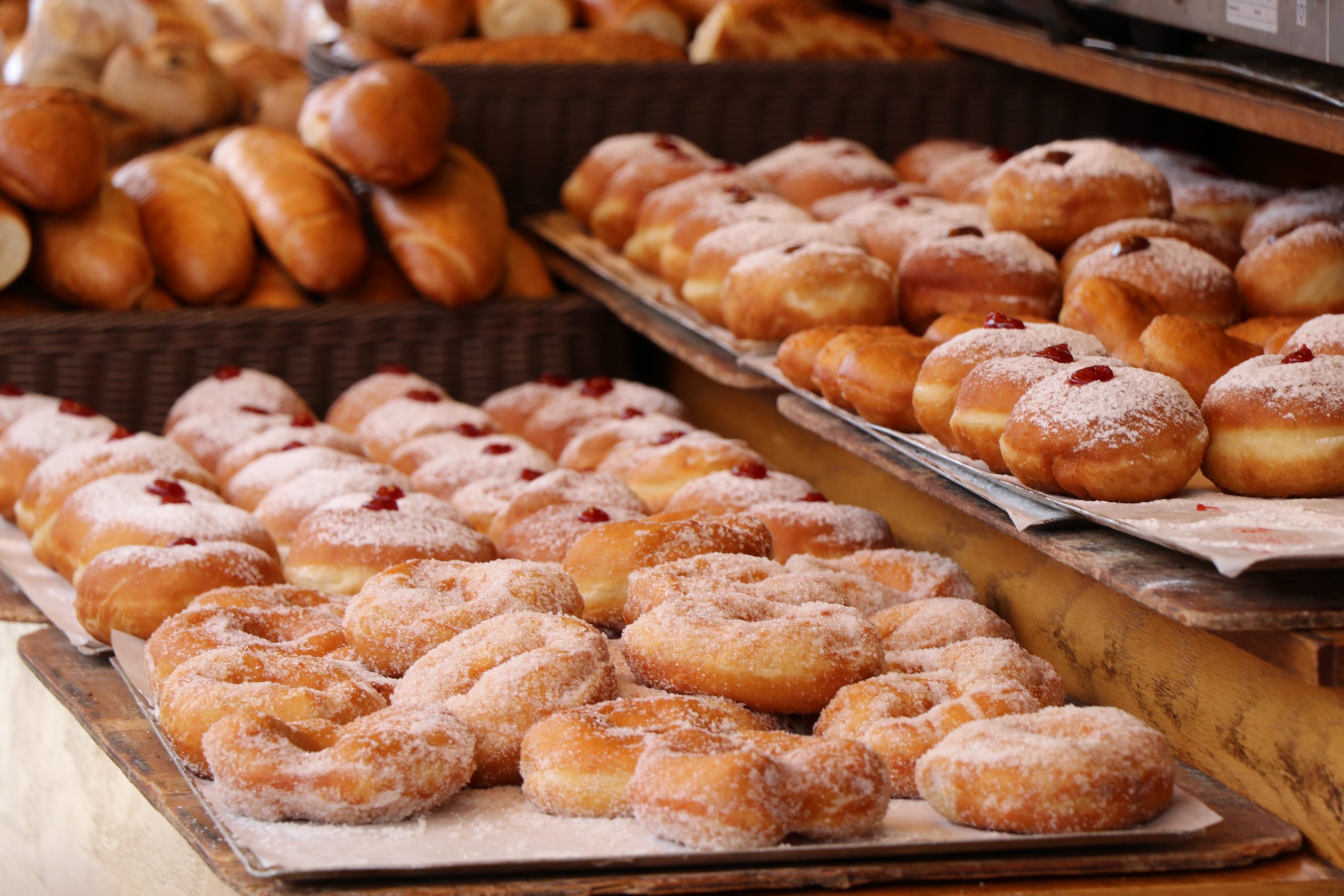 Reihen von gezuckerten Donuts und Gebäck säumen die Bäckereitheke und verleihen jeder Weihnachtsfeier eine süße Note.