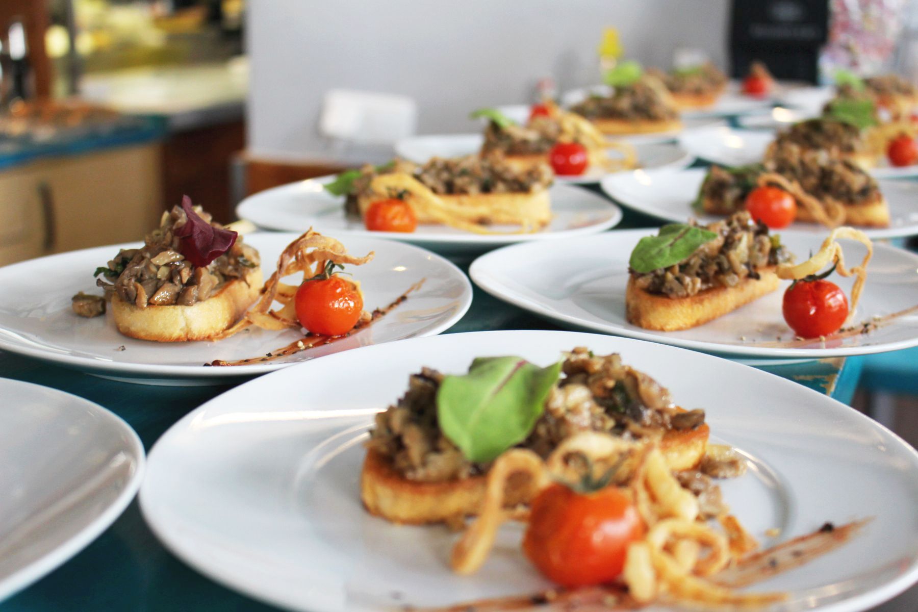 Teller mit Bruschetta, belegt mit Pilzen, garniert mit Kirschtomaten und Gemüse, sind eine herrliche Geschenkidee für jeden Feinschmecker.