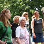 Eine Gruppe von Frauen steht an einem sonnigen Tag draußen in einem Park.