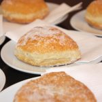 Mit Zucker überzogene Donuts auf Tellern mit Servietten.