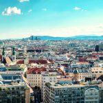 Panoramablick auf die Wiener Stadtlandschaft mit historischen Gebäuden und dem Stephansdom unter blauem Himmel.