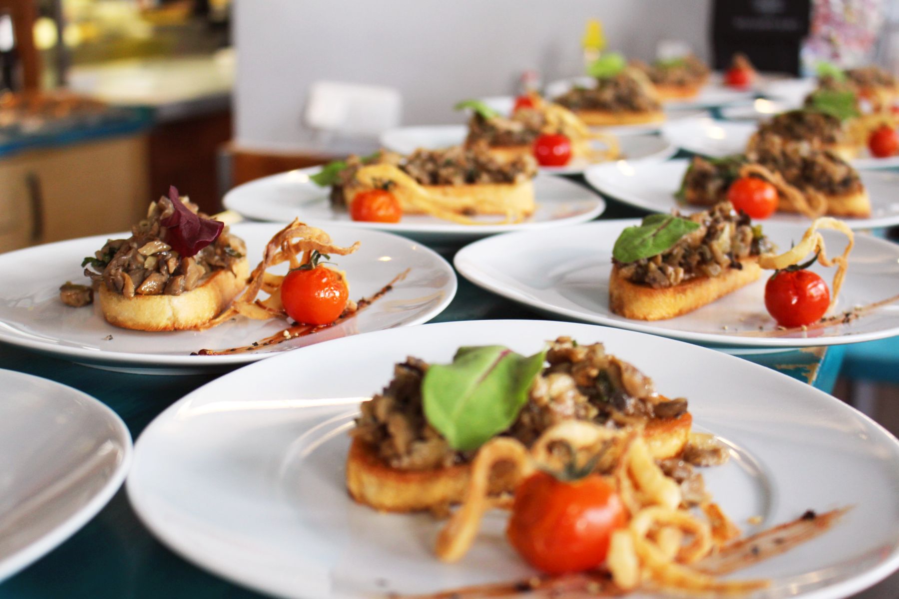 Genießen Sie während des Betriebsausflugs Teller mit Bruschetta mit Pilzen, garniert mit Kirschtomaten und frischem Gemüse.