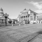 Ein Schwarzweißfoto zeigt Berlins neoklassizistischen Platz Friedrichswerder mit seinen historischen Gebäuden und der großen Kuppel unter einem bewölkten Himmel und lädt Sie zu einer Historischen Tour ein.