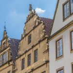 Historische europäische Gebäude mit verzierten Giebeln unter einem blauen Himmel.