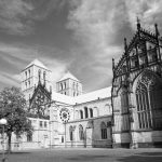 Ein Schwarzweißfoto zeigt die historische Kathedrale mit gotischer Architektur im Herzen der Altstadt. Unter einem teilweise bewölkten Himmel ist dieses ikonische Münster ein Highlight auf jeder historischen Tour.