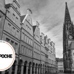 Schwarzweißfoto der St.-Lamberti-Kirche und historischer Gebäude in Münster, Deutschland.