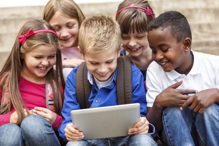 School children using digital tablet outside